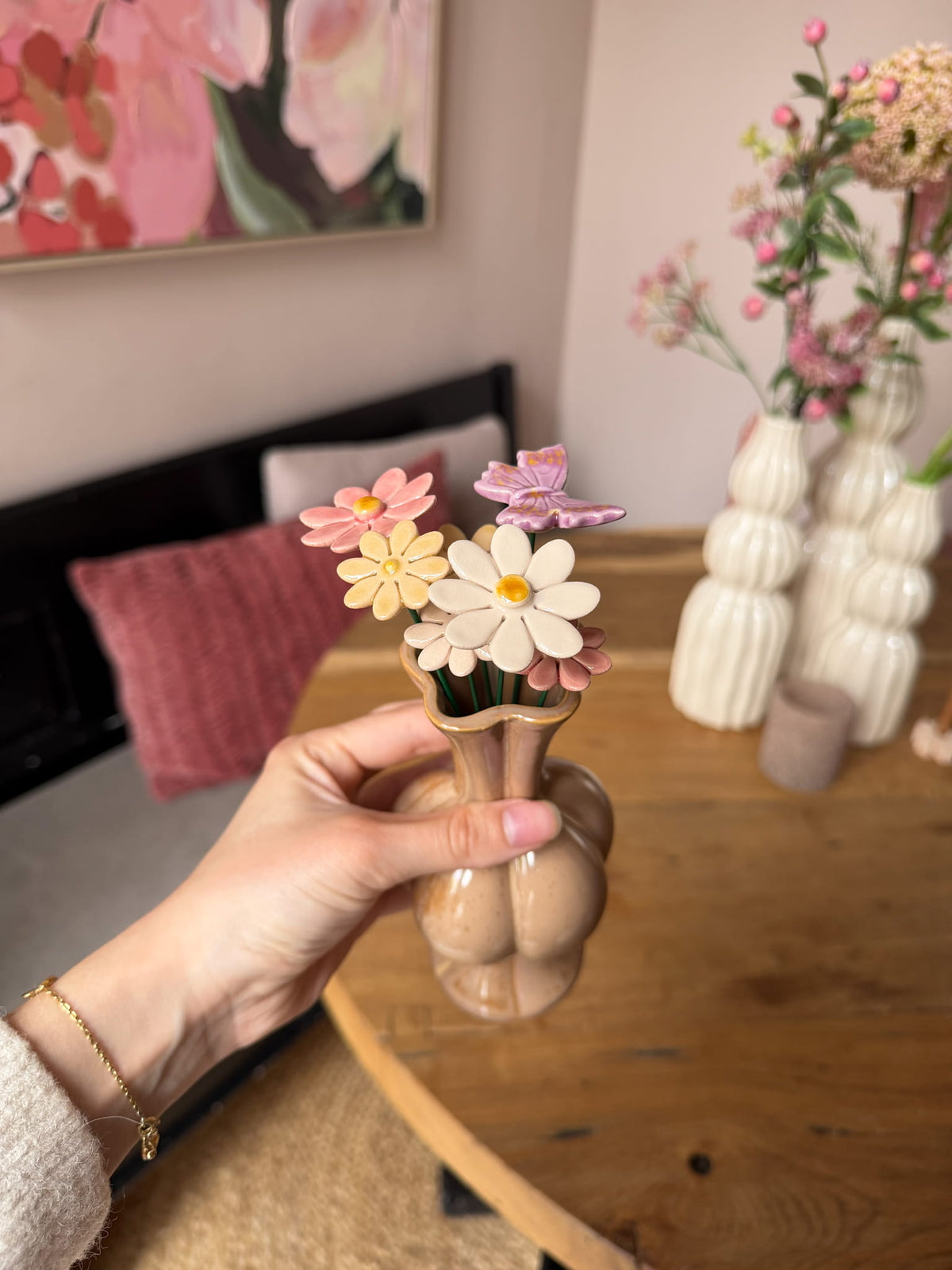 Handgemaakte keramieken vlinder met bloemen in een roze vaasje